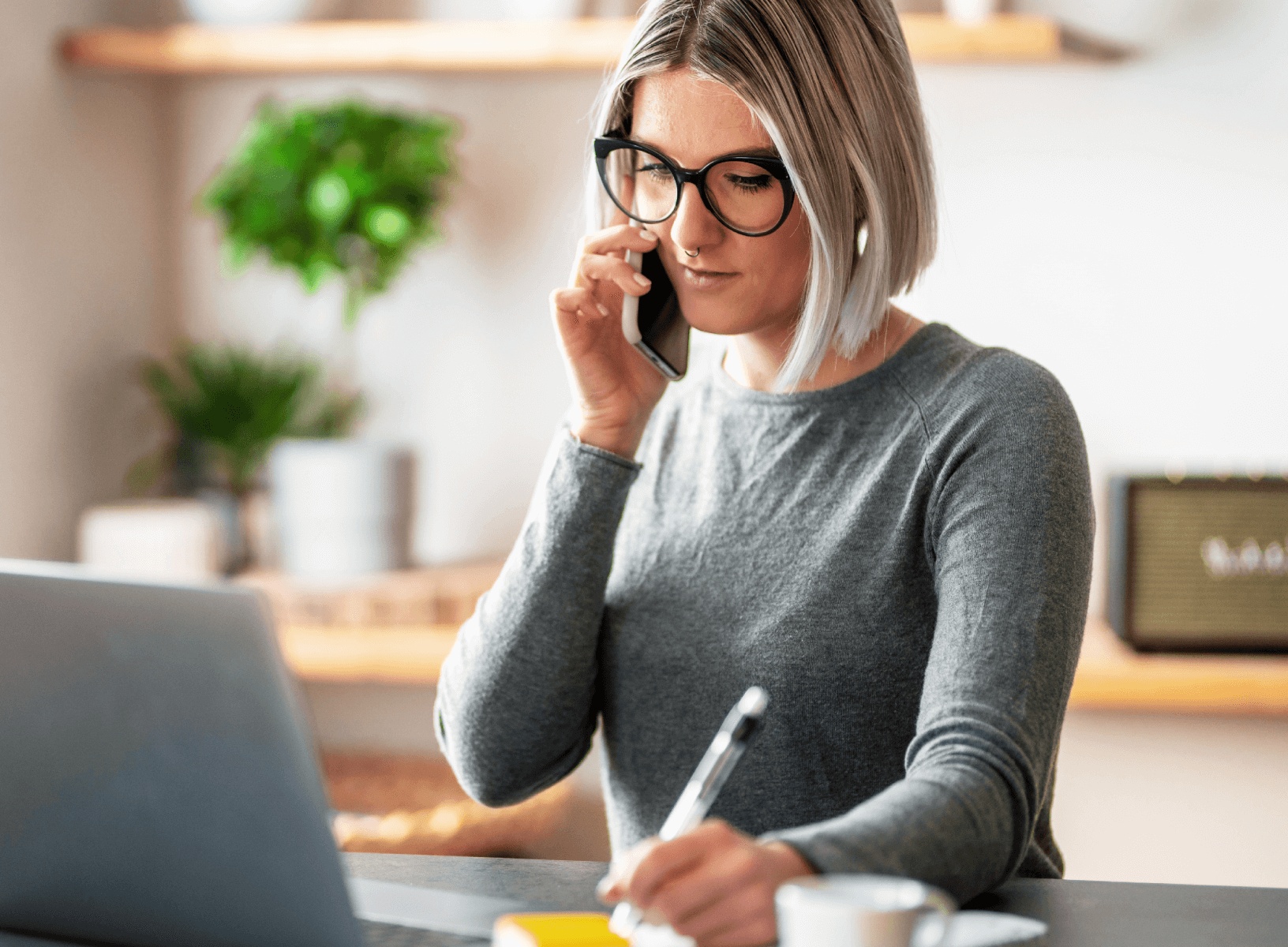 woman talking on the phone in front of a laptop